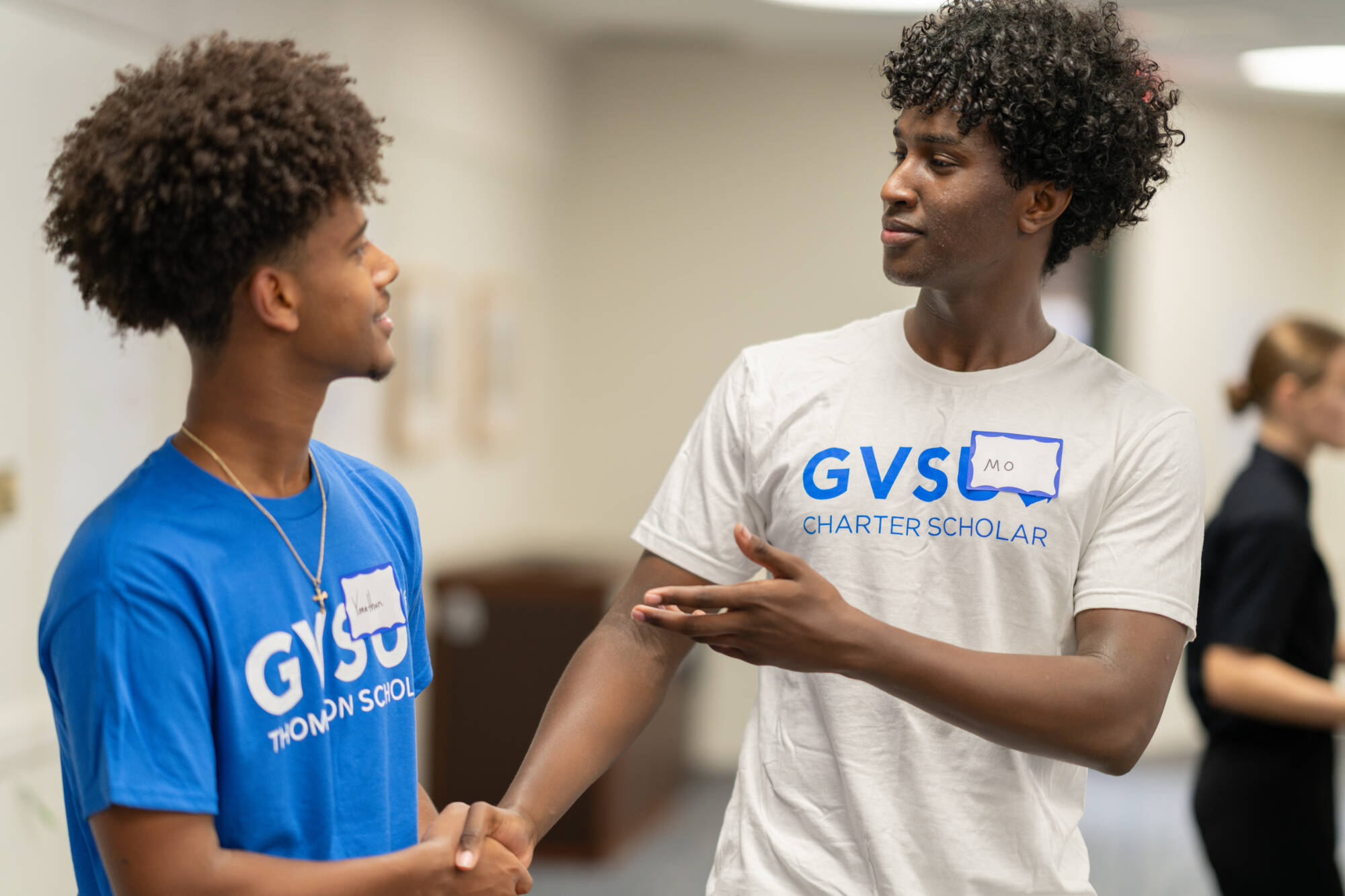 A photo of a Thompson and Charter Scholar Student shaking hands